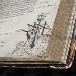 Colour photograph of an ancient book showing a doodle of a ship in ink
