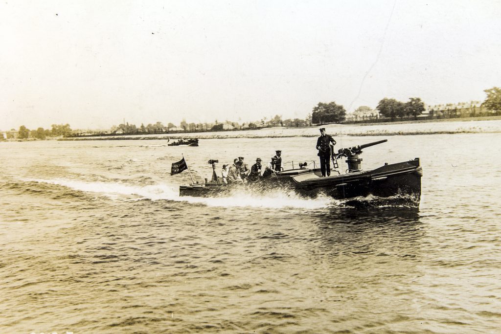 A black and white photography showing a group of people in a boat on a river