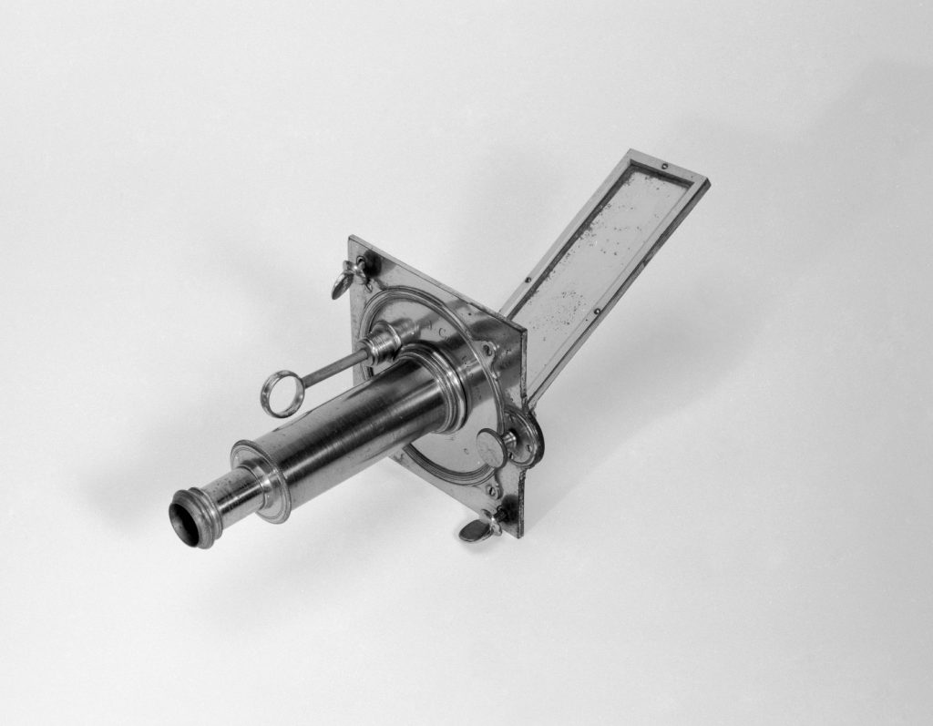 Black and white photograph of a Solar microscope accessory Cuff's second pattern comprising mounting plate with fixing screws mirror with adjustments and tube with condensing lens
