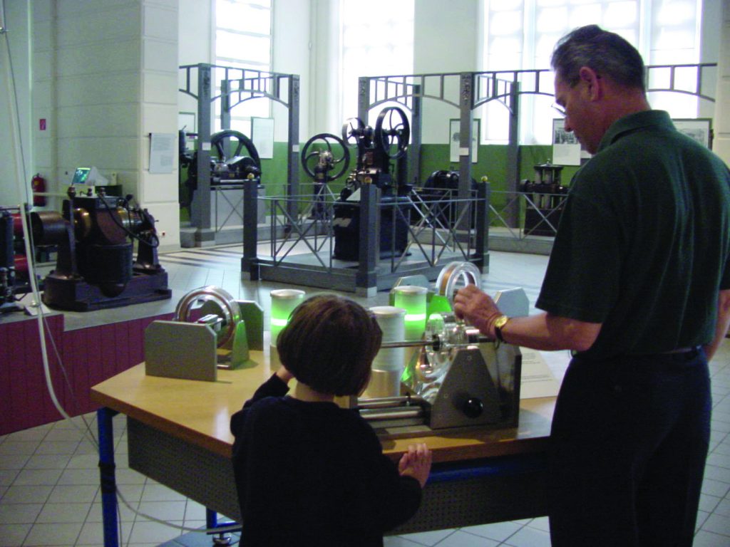 Colour photograph of museum goers using experimentation devices within a museum exhibition on energy