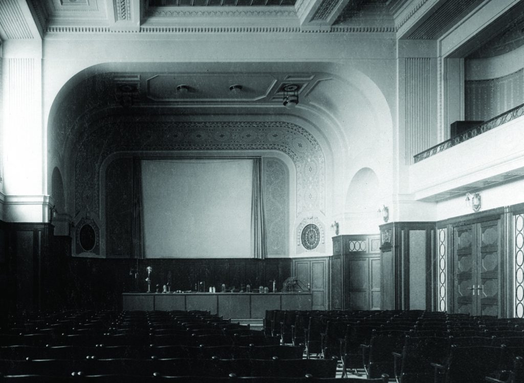 Black and white photograph of the interior of a large auditorium within a technical museum
