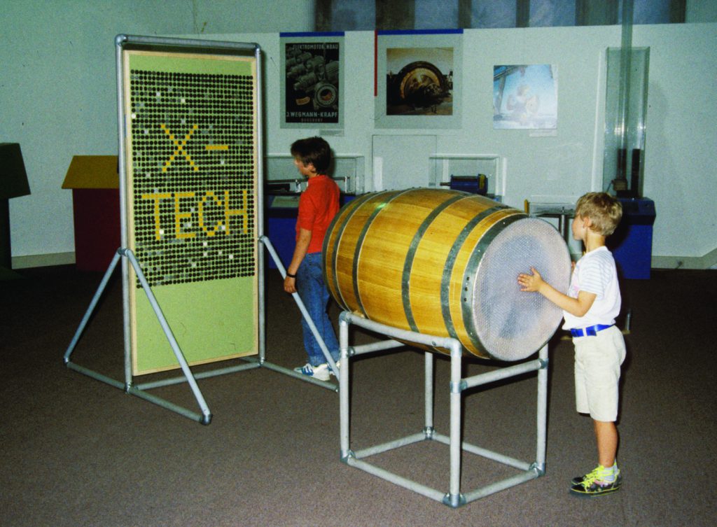 Colour photograph of museum goers using display items at a museum science centre