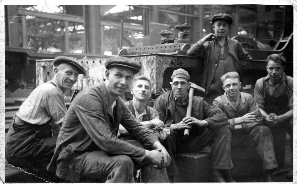 Black and white photograph of a number of male railway workers taking a rest