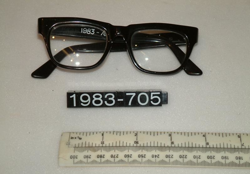 A photograph of a pair of man's spectacles with a black frame