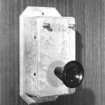 Black and white photograph of a wall mounted telephone from the late 1800s