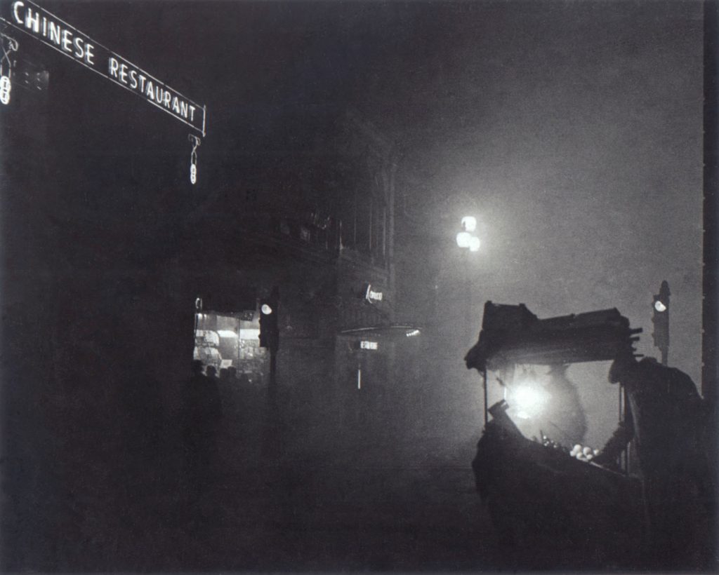 Black and white night time photograph of a street food stall outside a chinese restaurant
