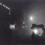 Black and white night time photograph of a street food stall outside a chinese restaurant