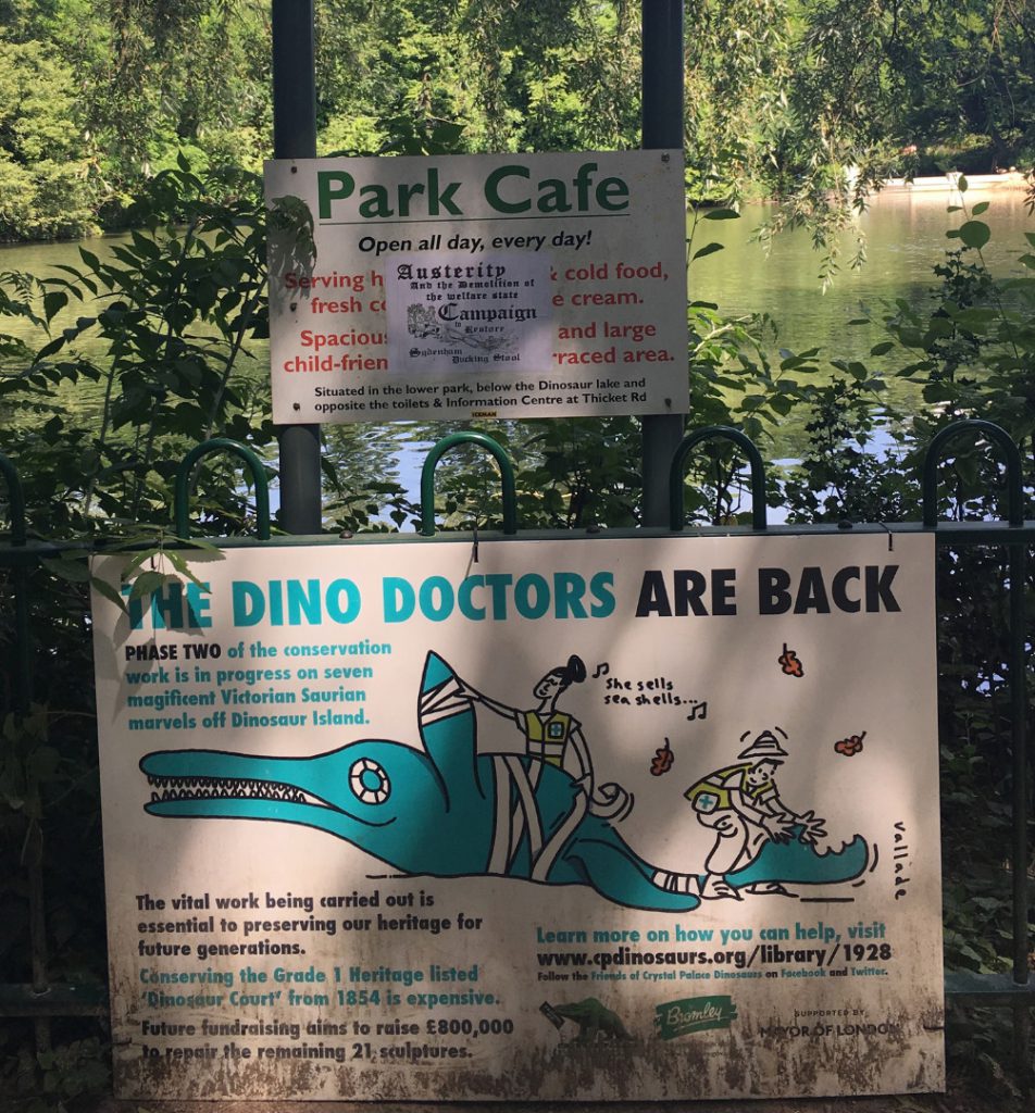 Colour photograph of a poster informing public that conservation work will be carried out on the concrete dinosaurs