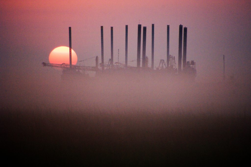 Colour photograph of a sunrise over an oilfield in Texas North America