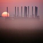 Colour photograph of a sunrise over an oilfield in Texas North America