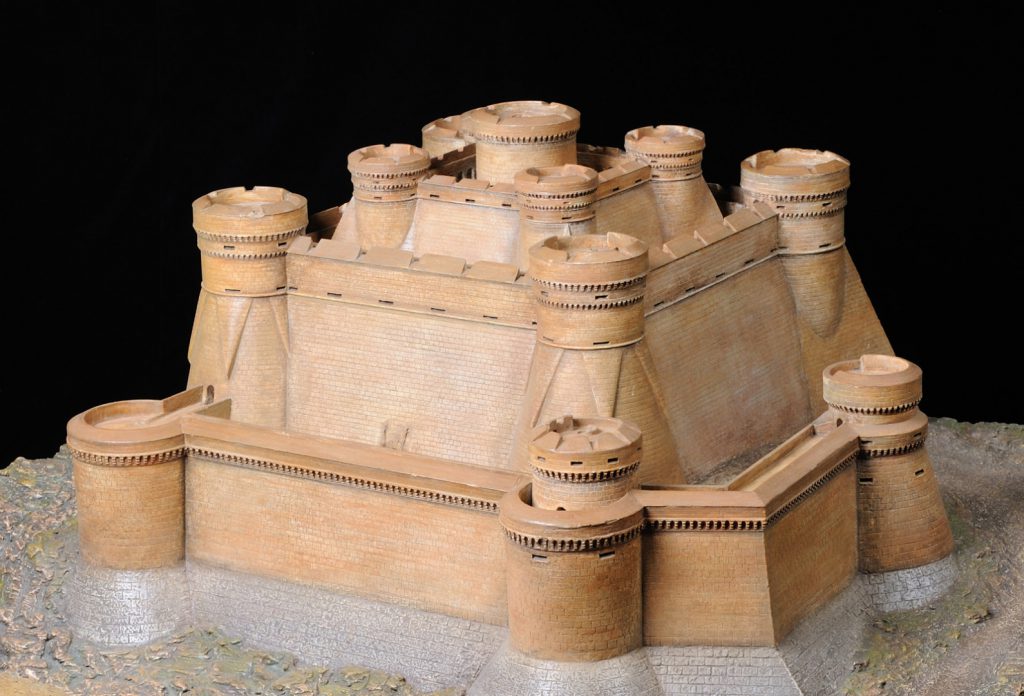Colour photograph of a painted model of a mountain fortress