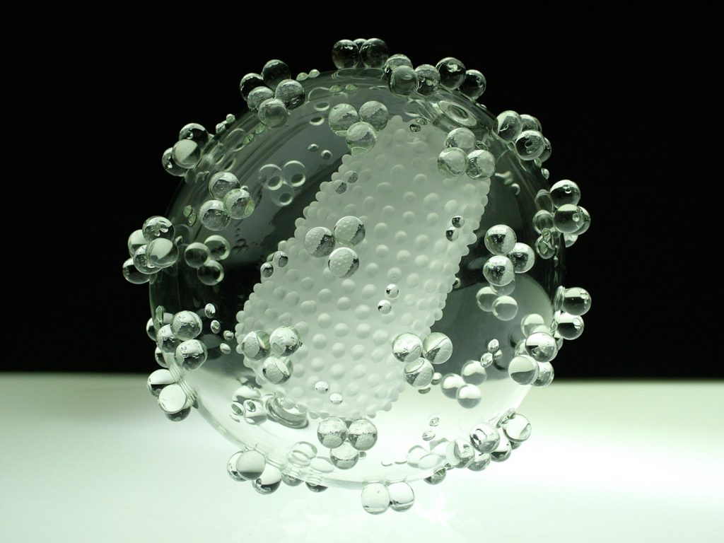 Colour photograph of a large scale glass sculpture of an HIV virus