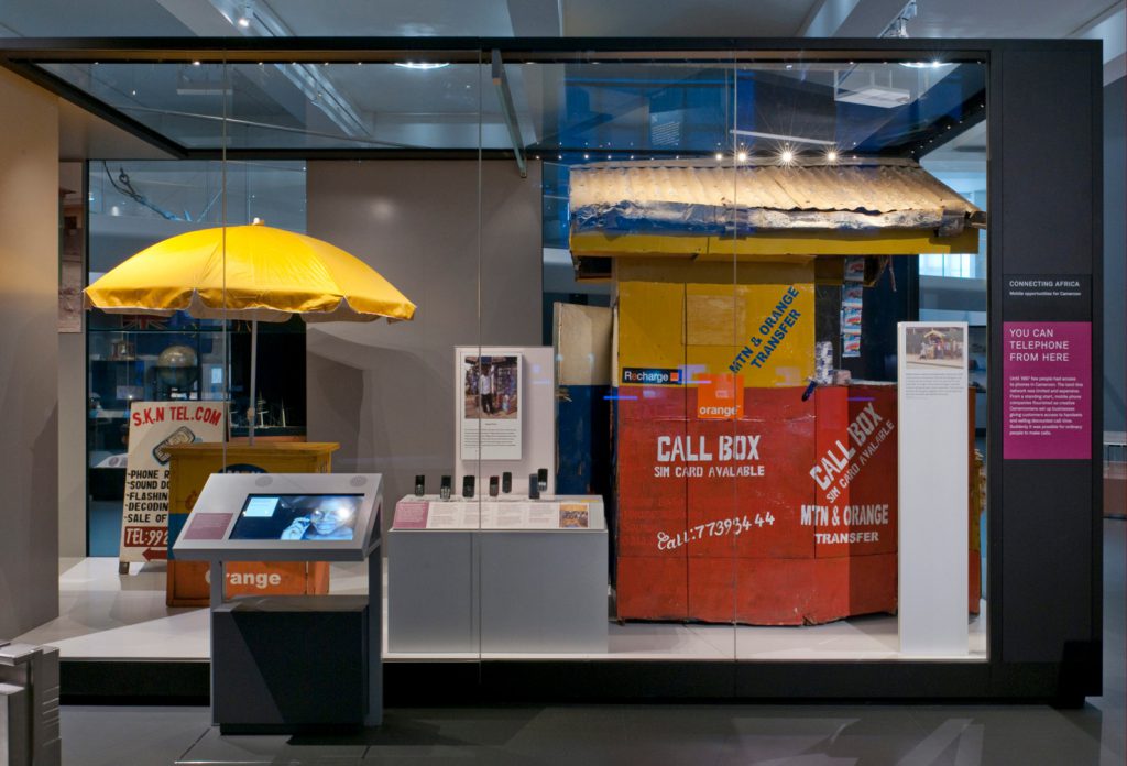 Colour photograph of the connecting Africa display in Information Age showing a mobile phone repair hut from Cameroon