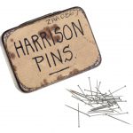 An old liquorice tin labelled with the words Harrison pins and a number of small dressmakers pins