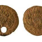 Colour photograph of the front and reverse side of a coin amulet of healing