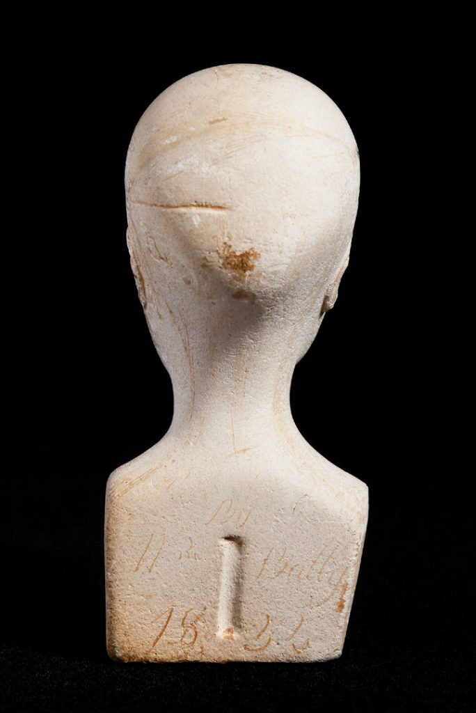 Reverse view of miniature phrenology bust showing inscription
