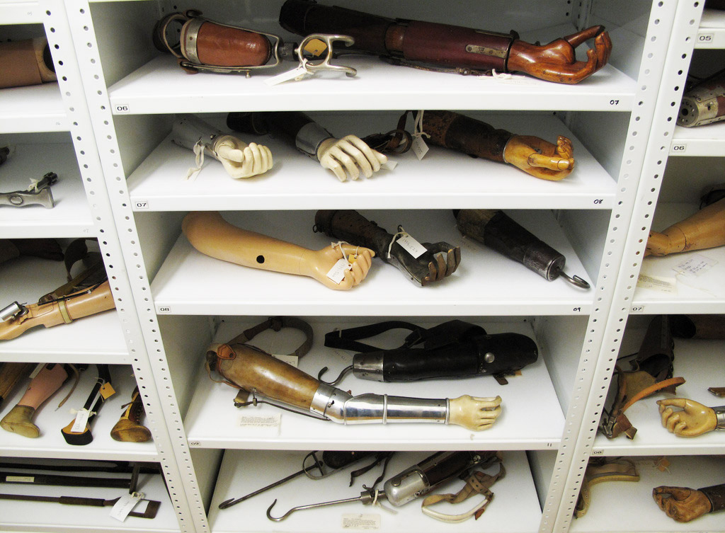 Colour photograph of a number of prosthetic arms in museum storage shelves