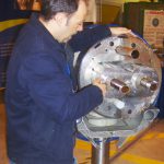 A CERN magnet engineer talks as points out features on a cross section of a circular super-conducting magnet
