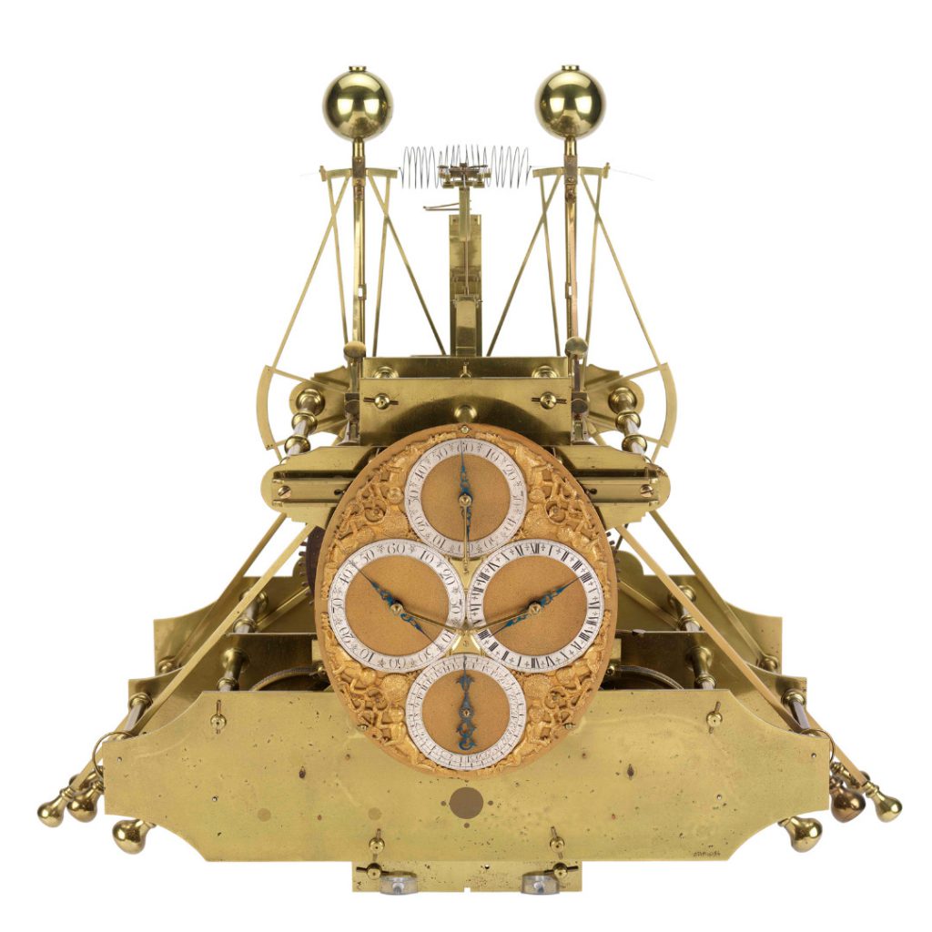 A large ornate brass chronometer with four dials on the face