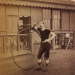 Sepia photograph of a cyclist with his high wheeler bicycle from the late nineteenth century