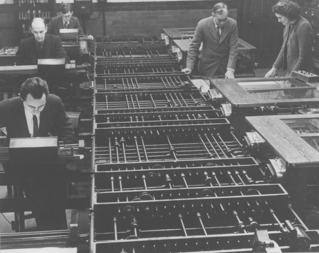 Black and white photograph of a number of people working on a differential analyser machine