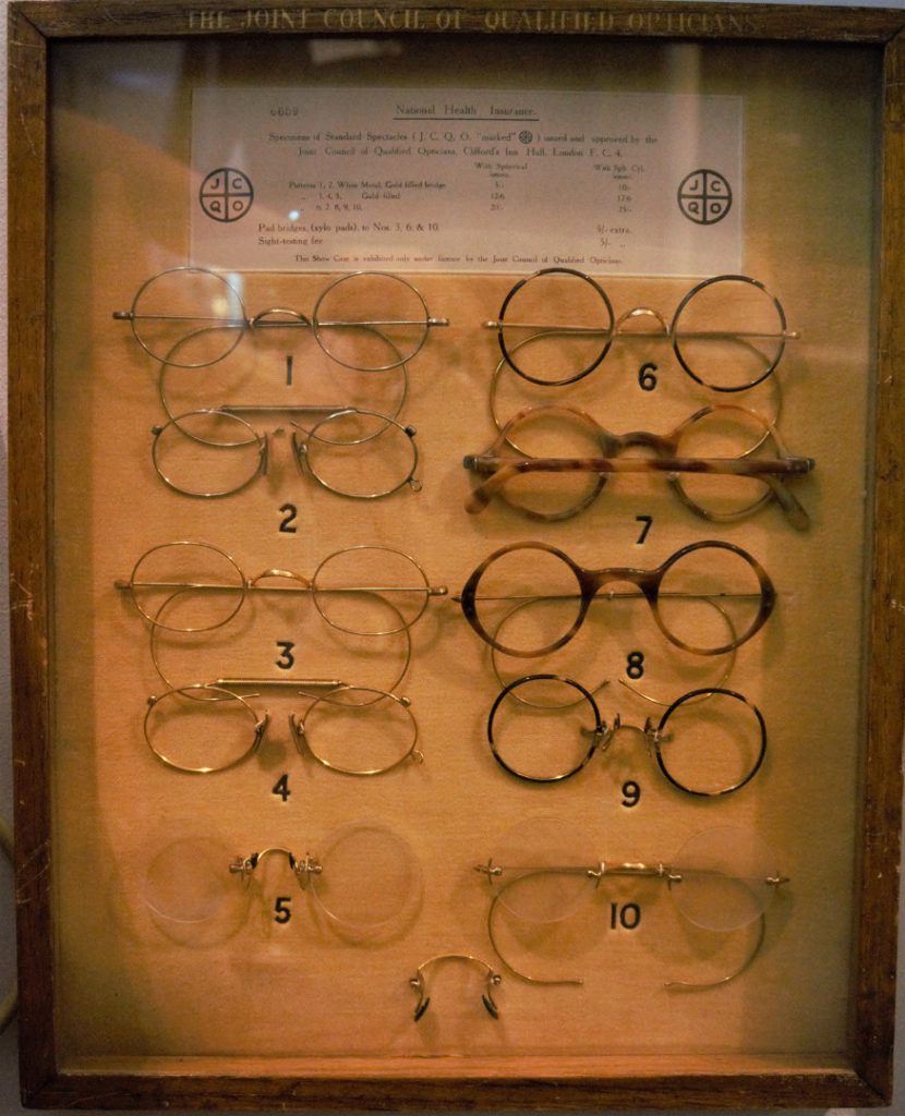 Colour photograph of a display case showing various styles of NHS spectacles
