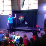 Colour photograph of a science museum explainer giving a demonstration to school children