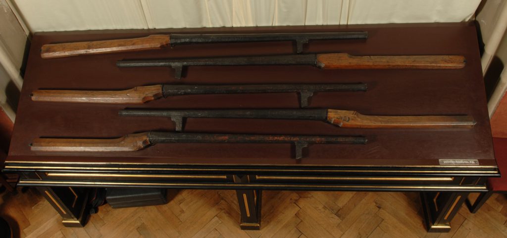 Museum table displaying five rifle style firearms from the seventeenth century