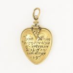 Colour photograph of an engraved heart shaped gold pendant