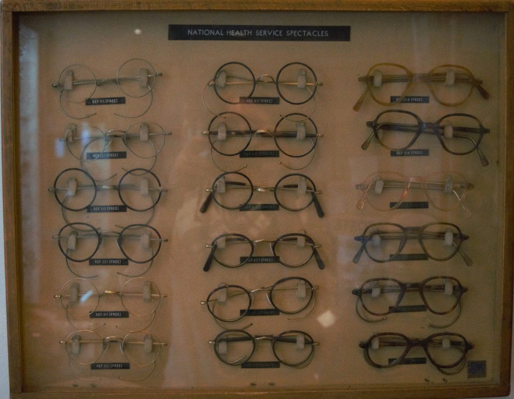 Colour photograph of a 1950 display case showing various styles of NHS spectacles