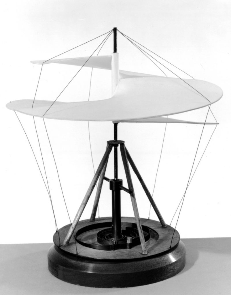black and white photograph of a working model of a static helicopter sail on a wooden base