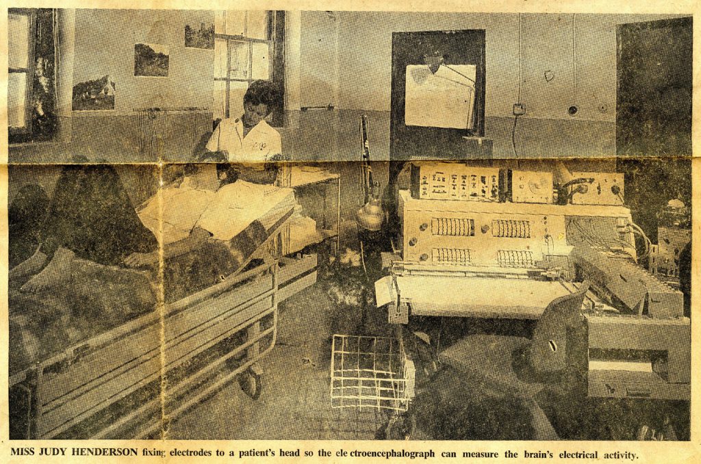 Newspaper clipping showing a nurse fixing electrodes to a patients head in a laboratory