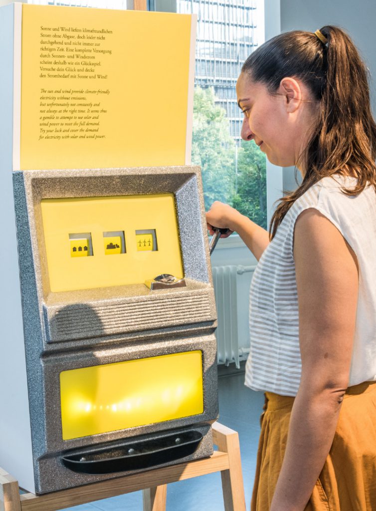 Colour photograph of a museum visitor interacting with a slot machine display case