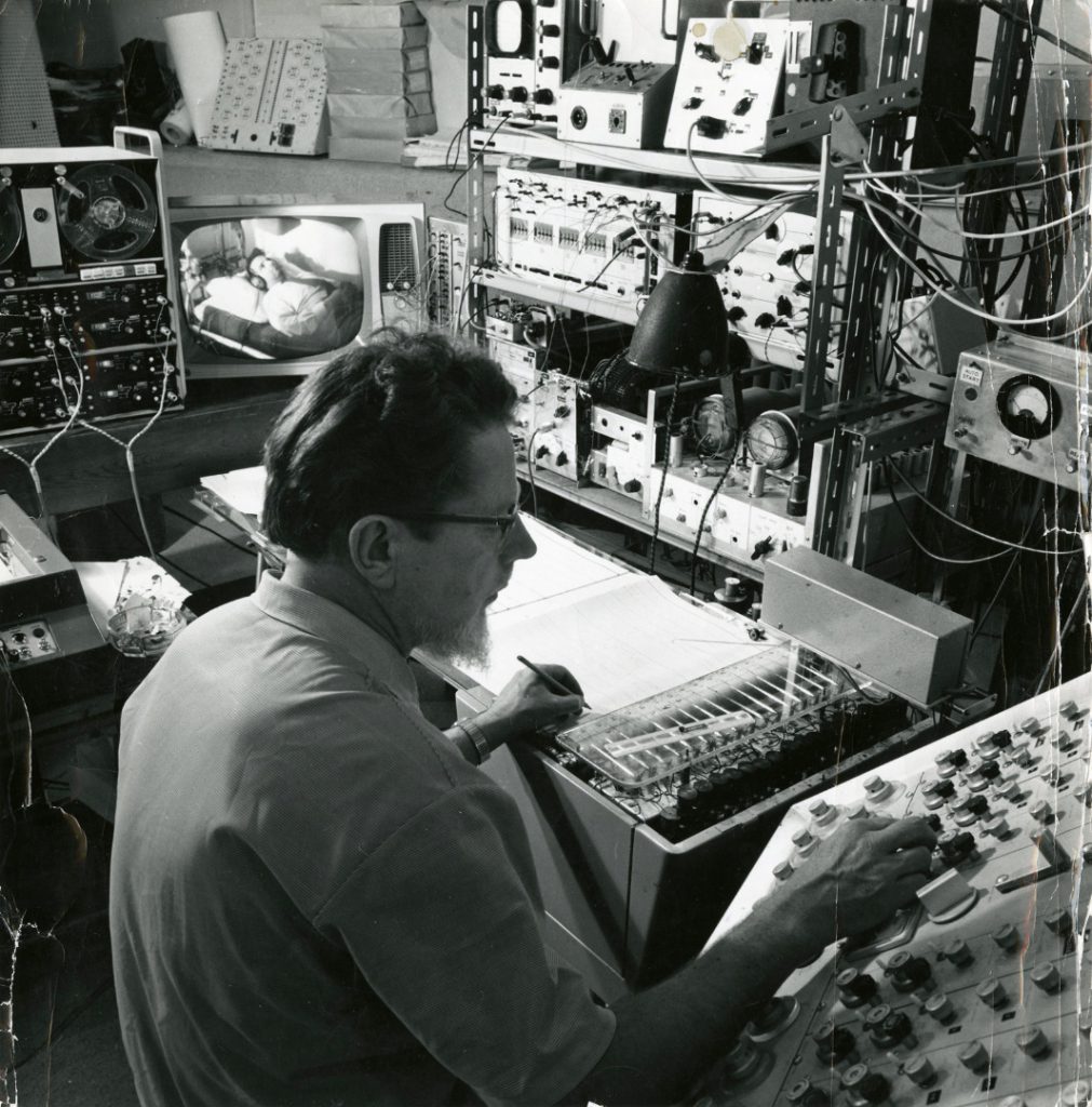 Black and white photograph of William Grey Walter and a 16 channel EEG