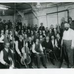 Black and white photograph of the Berlin Philharmonic Orchestra with their instruments in a Gramophone recording studio