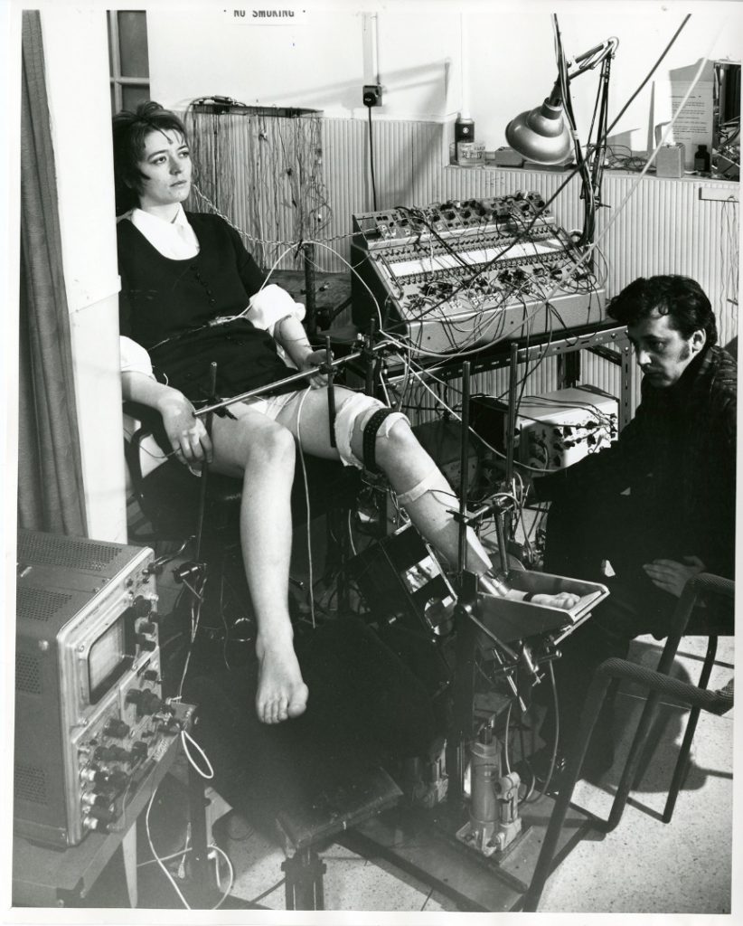 Black and white photograph of a neurologist seated before a female patient