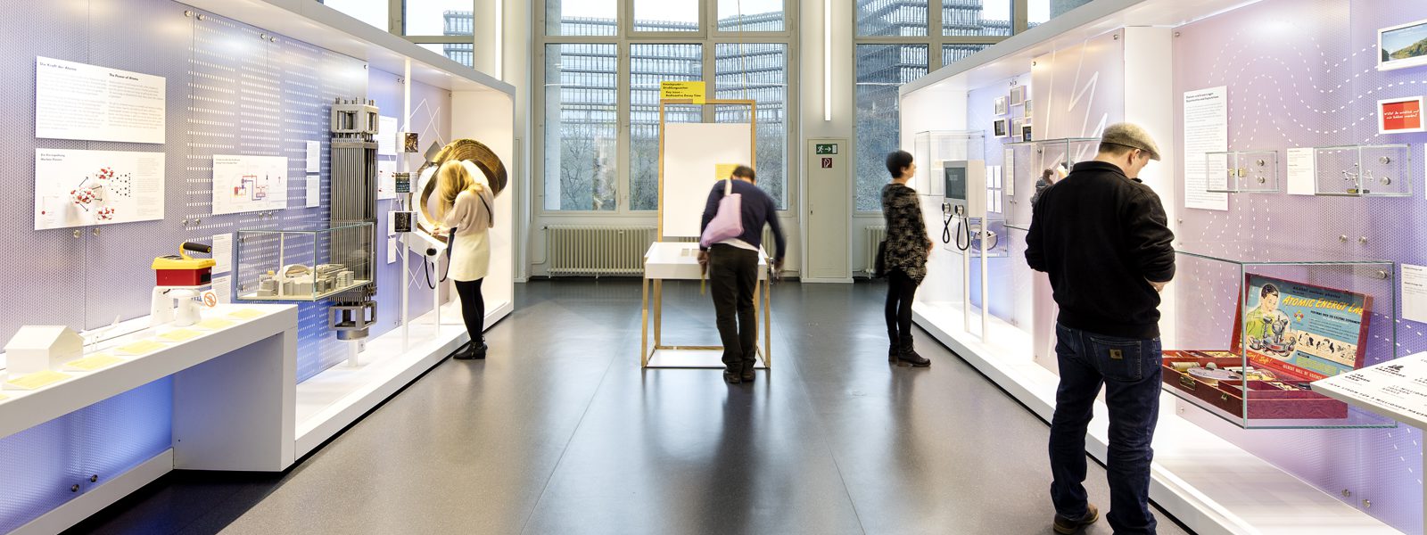 Colour photograph of a bright exhibition space with display objects and visitors