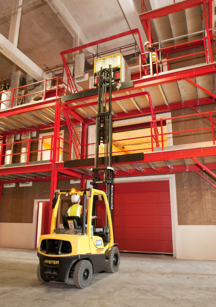 Colour photograph showing transportation of objects to upper storeys of the structure using a forklift truck