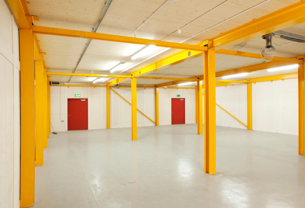 Colour photograph of the ground floor area of the newly completed storage area showing lain floor and steel beams
