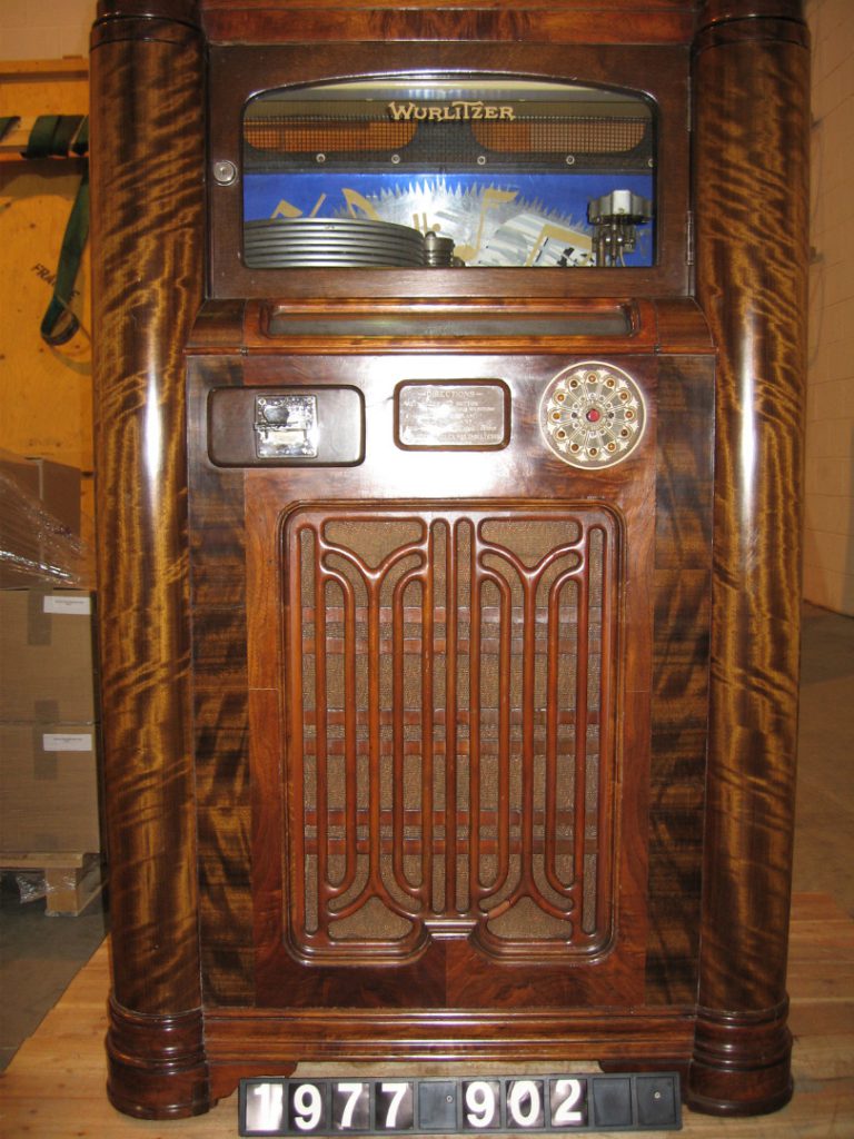 Colour photograph of a wooden multi selector Wurlitzer jukebox from 1936