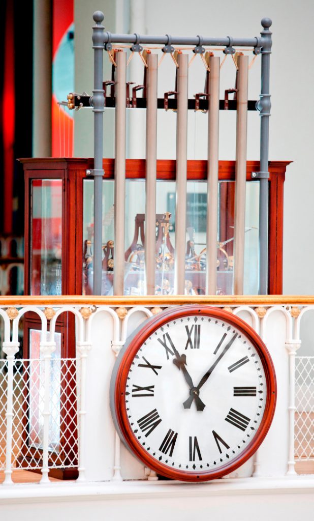 Colour photograph of a working model of a tower clock fitted with five tubular bells