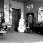 Black and white photograph of a small exhibition of scientific objects within a physics laboratory