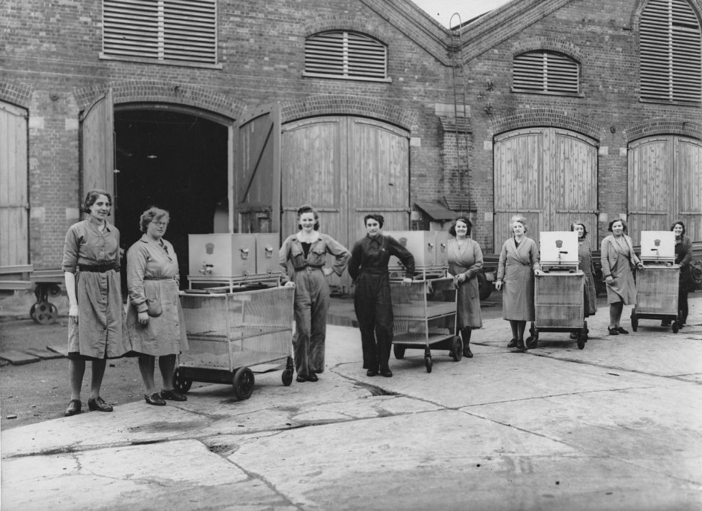 Black and white photograph of a number of women standing with their tea trollies