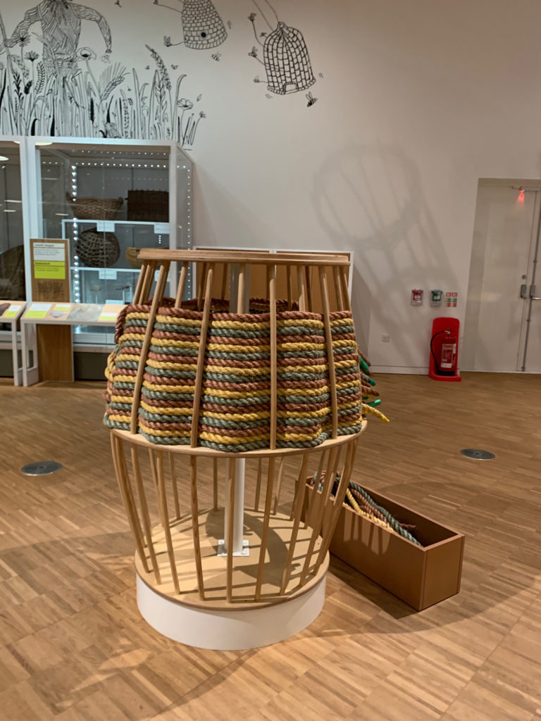 Colour photograph of a basket making themed interactive display in an exhibition gallery