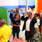 Colour photograph of museum goers using hand held viewing devices within an exhibition of colour