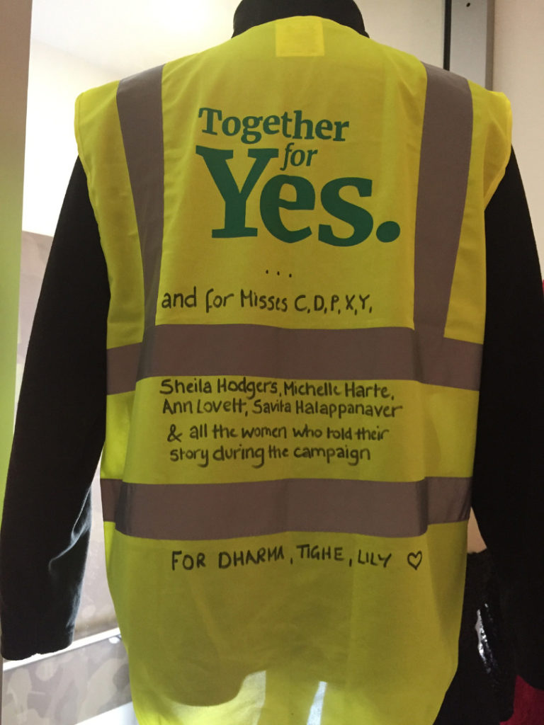 A yellow high vis vest printed with the words Together for Yes
