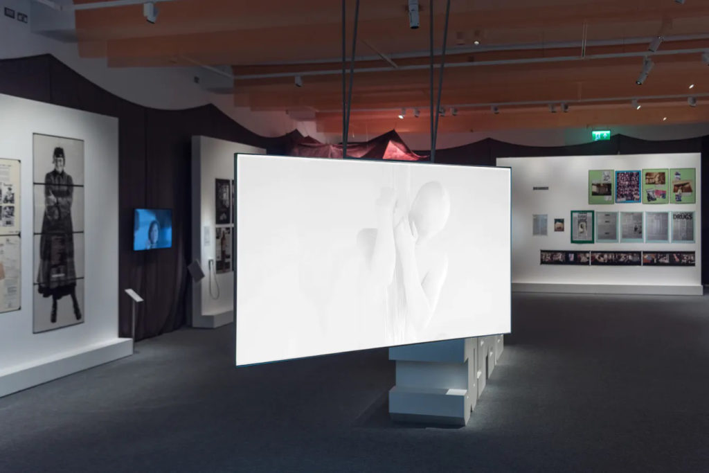Gallery view of the Jo Spence exhibition showing a large video screen