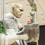 Colour photograph of a large human sculpture wrappend in cellophane for transportation