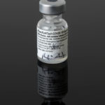 Colour photograph of the first used COVID vaccine bottle