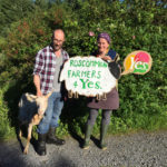 A farming couple hold a sign which reads Roscommon Farmers for Yes